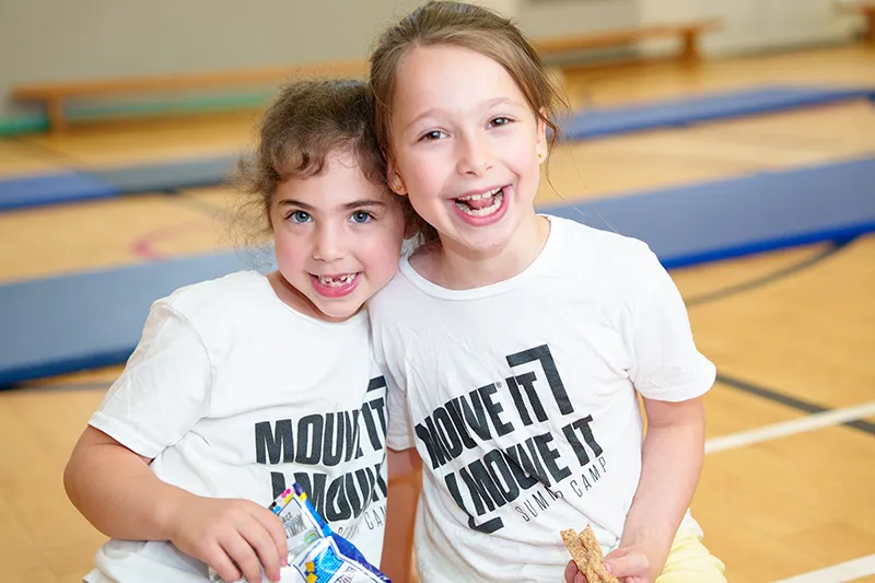 Two girls in MOUVE t-shirts having fun at a dance and games party