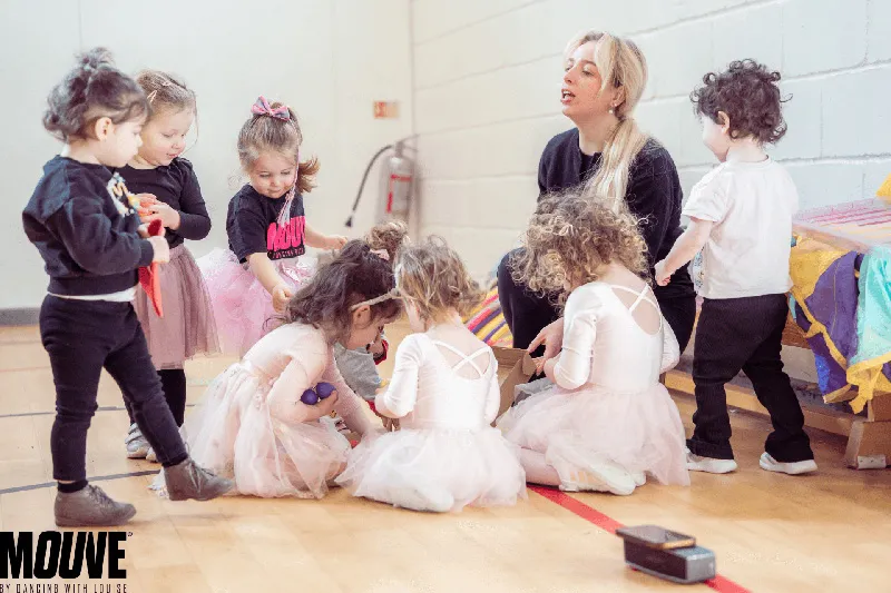 Toddlers in tutus with their teacher at a Little Ones dance party