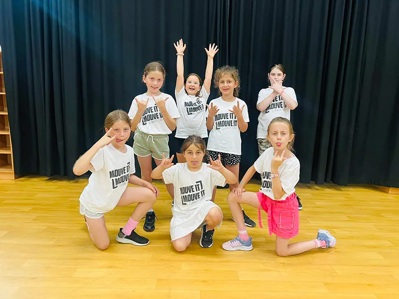 Children acting and dancing in a musical theatre birthday party